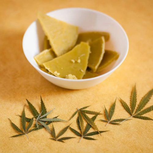 solid weed butter in a bowl with cannabis leaf